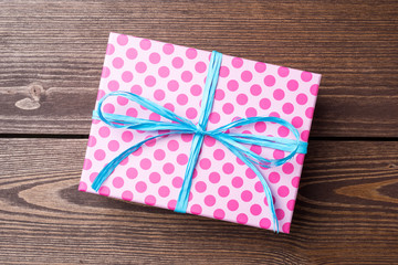 Pink dotted gift box on wooden table