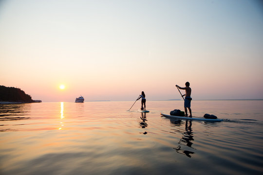 Attractive Young couple Stand Up Paddle Boarding,