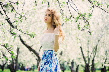 Obraz na płótnie Canvas beautiful young woman in floral maxi skirt walking in spring