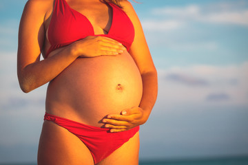 Happy pregnant woman at beach