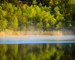 Early morning mist on lake during fall in Sweden