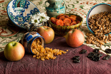 Obraz na płótnie Canvas dried fruit in cups on an oriental ornamented tablecloth. still life in oriental style