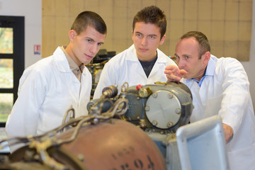 Engineers viewing mechanical exhibit