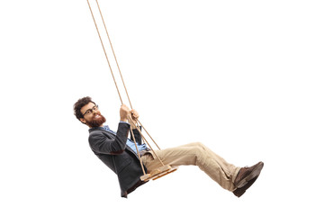 Bearded man swinging on a swing - obrazy, fototapety, plakaty