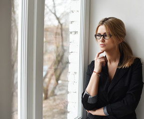 portrait of a girl in a business suit with glasses window