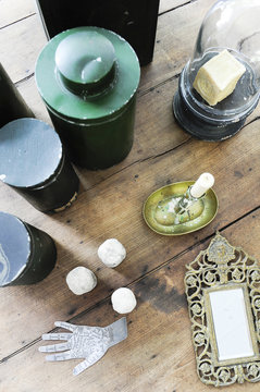 Atmosphere and objects of vintage decoration and chiné with mirror, metal boxes and candlestick on an old wooden table