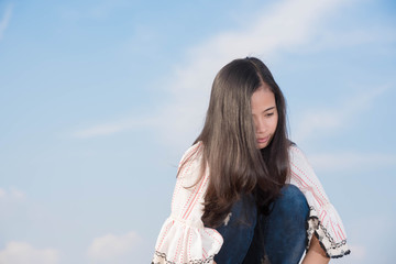 Young woman sitdown so sad on the mountein to sky background