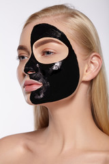 The face of the girl with black mask on her face.