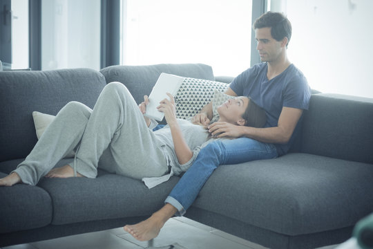 Young couple with tablet relaxing at home