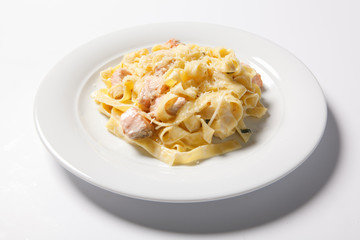 Pasta fettuccine alfredo with chicken, parmesan and parsley on white plate. Italian cuisine.