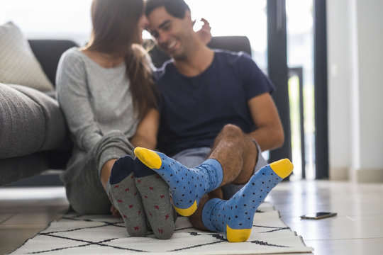 Young couple wearing patterned socks relaxing at home