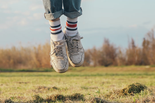 Shoes of man jumping on meadow