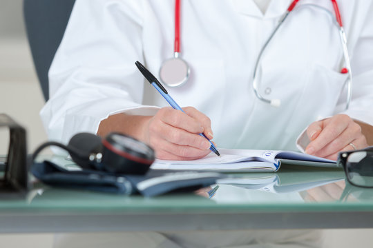 physician writing prescription-cropped image