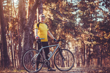 man cyclist rides in the forest on a mountain bike.