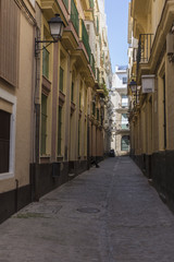 Fototapeta na wymiar Narrow street with traditional architecture in Cadiz, Andalusia, southern Spain