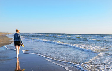 junge Frau spaziert barfuß an der Nordseeküste, Insel Rømø, Dänemark