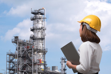 Female engineer wearing safety helmet inspects pipeline industry site