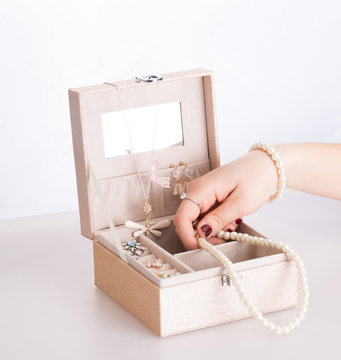 Portagioie in legno con mano che prende la bigiotteria