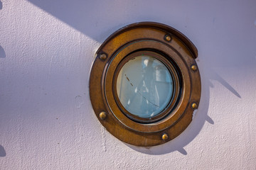 brass porthole ropes rigging masts and stays on traditional sailing ship