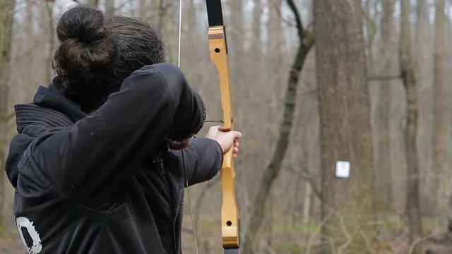 Man shoot with a bow in the forest