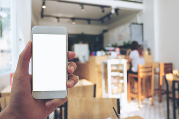 Mockup image of hand holding mobile phone with blank white screen in wooden cafe