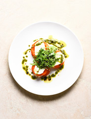 Tasty tomatoes sliced with mozarella cheese and green arugula salad