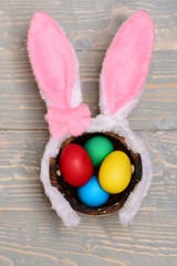 colorful eggs inside bucket and rabbit ears. Happy Easter concept