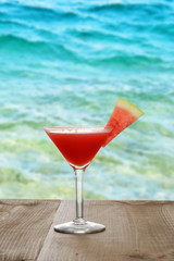 watermelon martini on table by ocean
