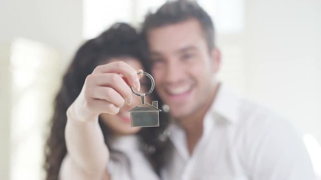  Happy couple in love holding key fob for key to their new home