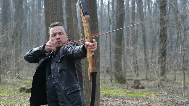 Man shoot with a bow in the forest