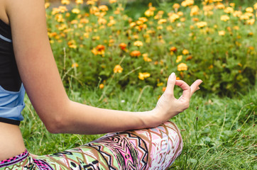 Young woman meditating in nature by the river. Natural light. Backlit by the sun.