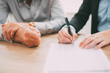 Unrecognizable woman signing contract at meeting