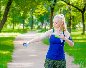 Woman spraying insect repellents on skin before run