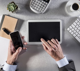 connected businessman hands multitasking on digital tablet and smartphone