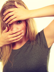 Obraz premium Ashamed embarrassed blonde woman with hands on face