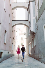 Fototapeta na wymiar Verliebtes Paar in Altstadtgasse mit rotem Kleid