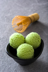 Green tea matcha ice cream scoops on gray stone background
