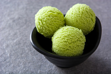 Green tea matcha ice cream scoops on gray stone background
