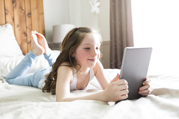 girl lay bed at home with tablet technology