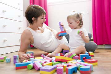 Obraz na płótnie Canvas mom and kid playing block toys at home