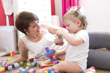mom and kid playing block toys at home