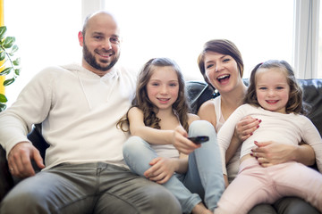 Family sitting in living room watching tv