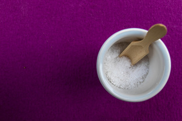 Fototapeta na wymiar Tasse mit Salz auf lila Hintergrund
