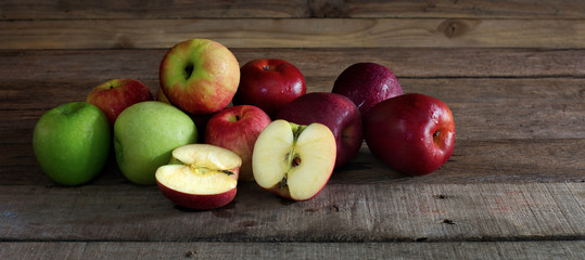 Pile of fresh apple put on old wooden background in dim light, Still life and select focus..