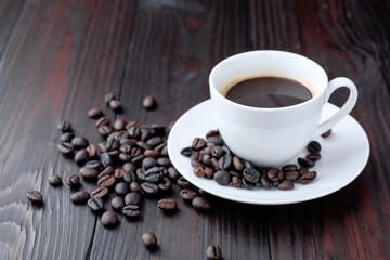 Coffee cup and coffee beans on wooden background