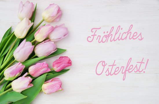 Ostern, Fr&ouml;hliches Osterfest!, Osterkarte mit Schrift und rosa Tulpen auf weissem Holz