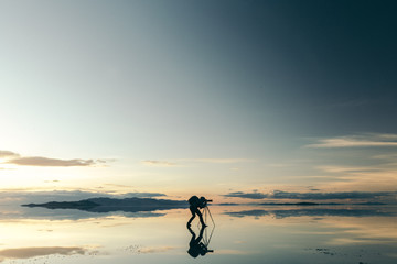 Silhouette of photographer taking picture with camera against sky