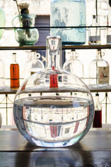Clear glass demijohn against a light background