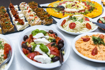 Colorful canape with vegetables and sausage on a slate plate