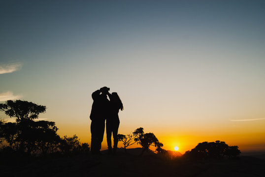Couple silhouette doing self at sunrise in Brazil